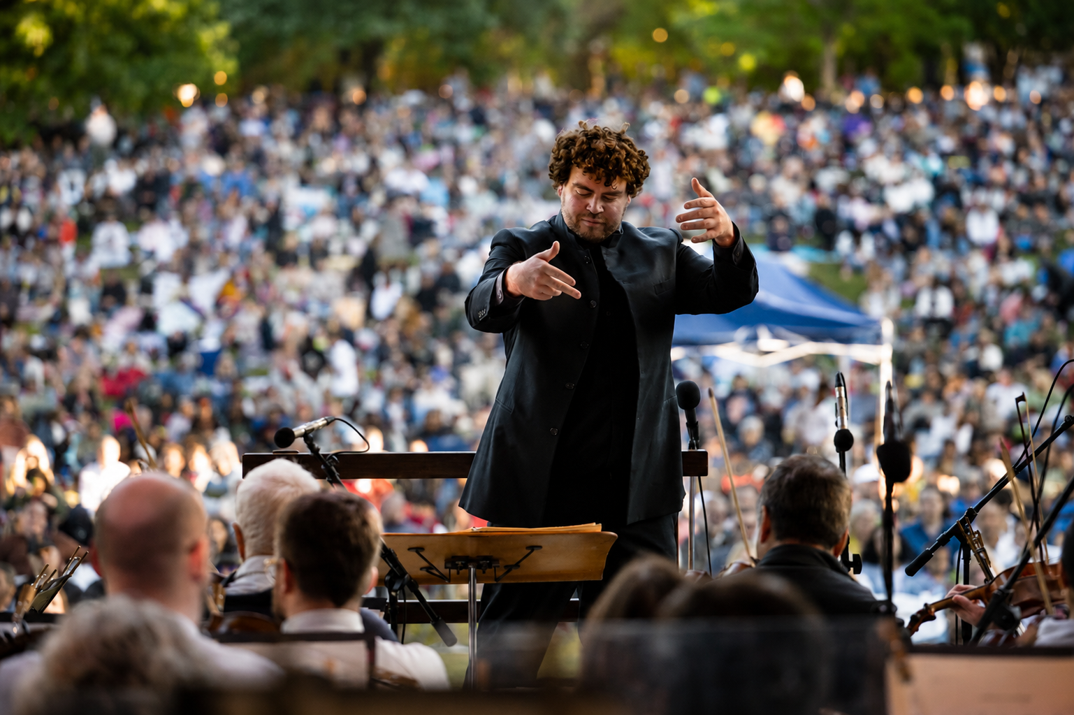 Finan Jones conducting an open-air concert in Piedmont Park, Atlanta. Credit: Adam Hagy.